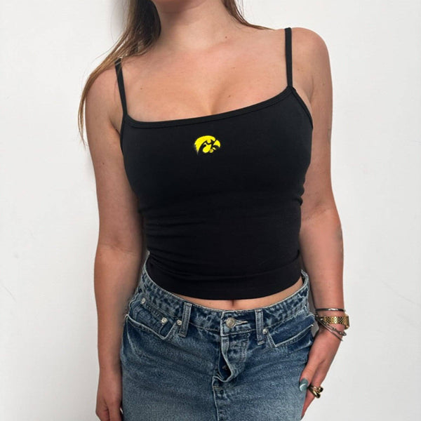 Person wearing a black tank top with a logo and a denim skirt on a white background